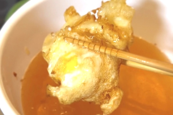 衣をまとった冷凍卵が160℃の揚げ油で揚げられ、とろける半熟たまご天ぷらに仕上がる瞬間