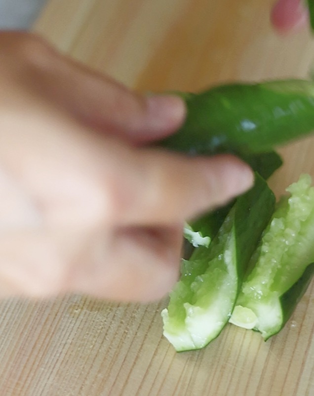 たたききゅうりを、棒を使わずに簡単に作る方法｜ひび割れたきゅうりを手で食べやすい大きさにちぎっている様子。