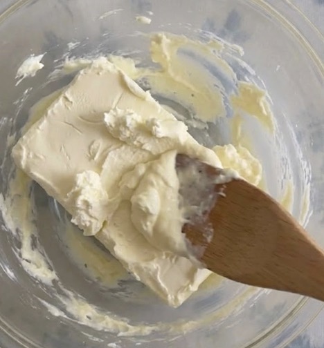 チーズケーキを作る工程：室温においたクリームチーズをゴムベラや泡立て器で滑らかになるまで練る。