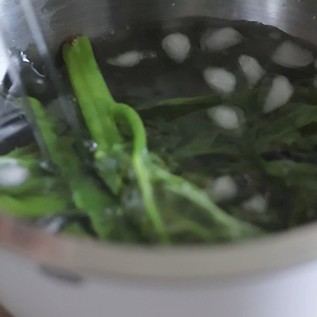 電子レンジで加熱したつるむらさきを氷水で冷やし、色止めをしている様子。シャキシャキ感を保つための下処理工程