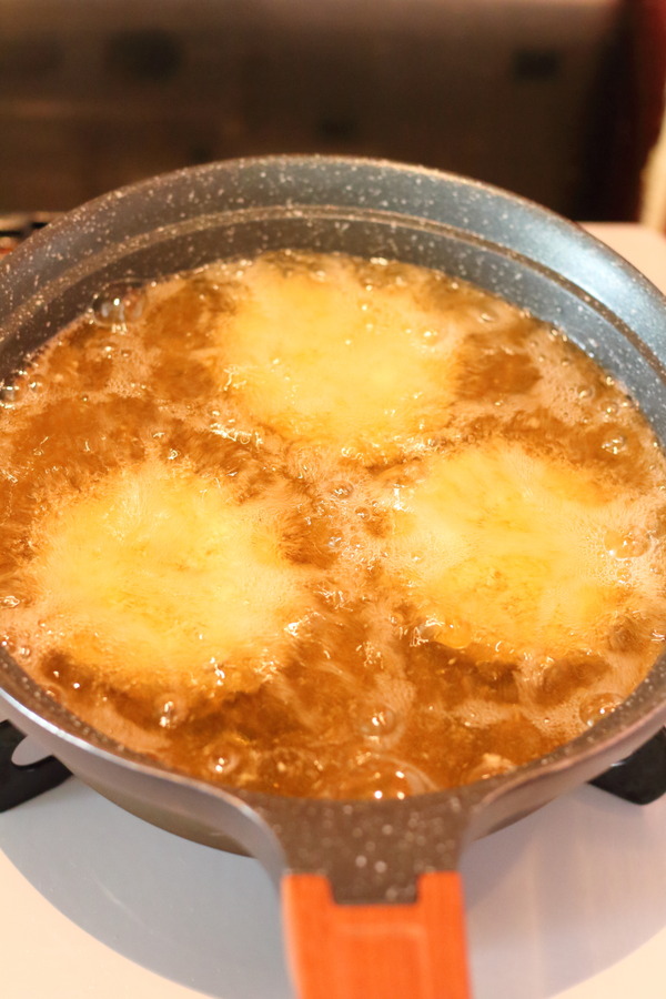 フライパンの油で揚げられているカレーコロッケ