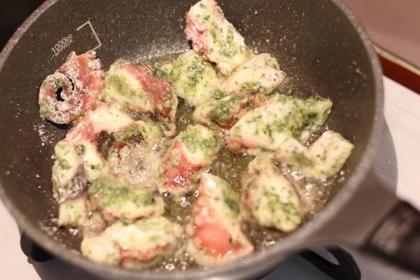 フライパンに少量の油でたこのジェノベーゼ唐揚げを揚げ焼きにしている調理風景