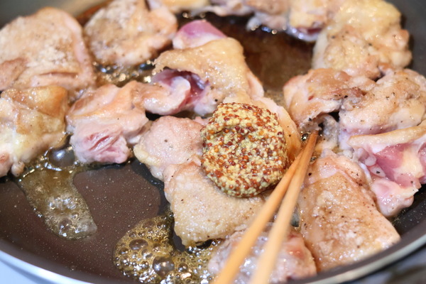 フライパンで焼くハニーマスタードチキン、鶏もも肉に粒マスタードとソースを絡める工程