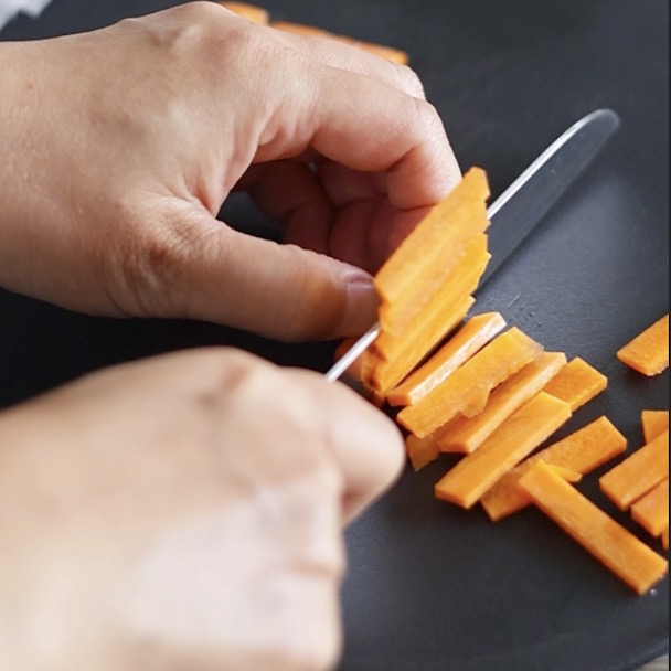 料理の準備として、人参を細切りにカットしている手元