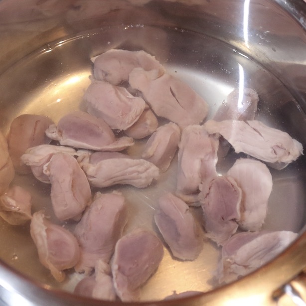鍋で茹でられている砂肝。加熱途中で色が変わっている