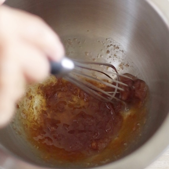 ボールの中で、梅干しと他の調味料を混ぜ合わせ和え衣もを作っている様子