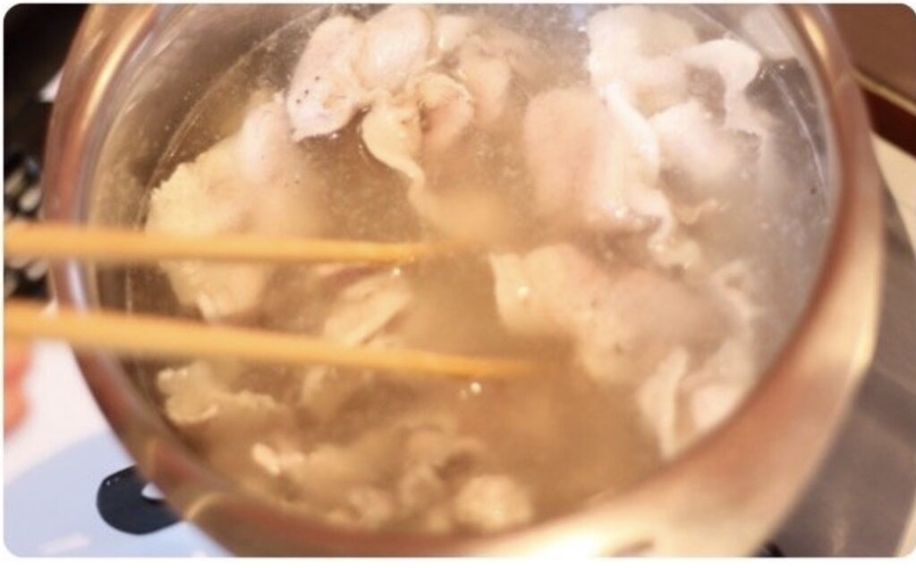 鍋で豚薄切り肉を茹でている様子