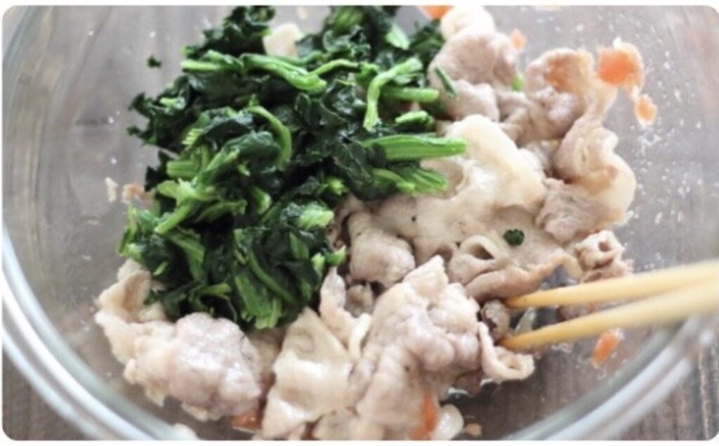 ほうれん草と豚肉をボウルで和えているところ