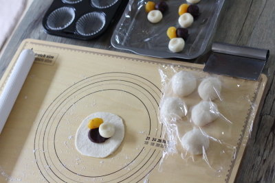 伸ばしたパン生地の中央に、こしあん、白玉団子、栗の甘露煮を乗せているところ。