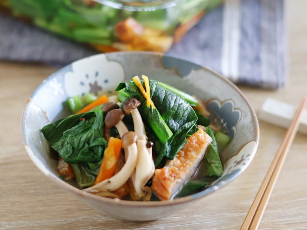 レンジ調理で手軽に作った「夏の煮浸し」を器に盛り付けている様子。小松菜、人参、さつま揚げ、きのこが彩り豊か