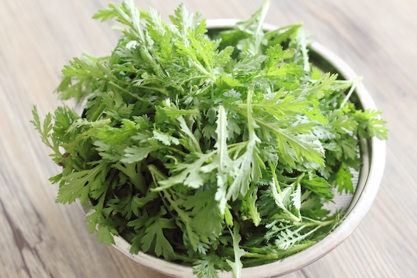 ボウルに入った、これから調理する新鮮な春菊。