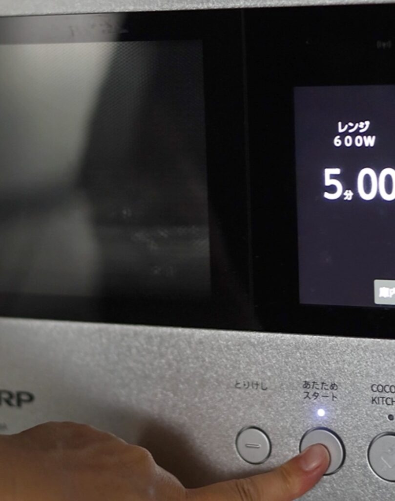 火を使わない豚バラ旨塩うどんのレシピ。電子レンジを600Wで5分に設定し、加熱をスタートする様子