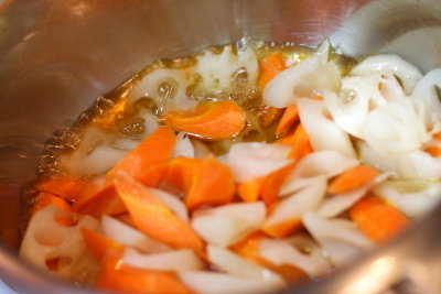 レンコンににんじんを加えて、 調味料の甘酢を入れる