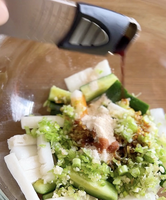 大根ときゅうりのピリ辛への調味料を加えて味付けする