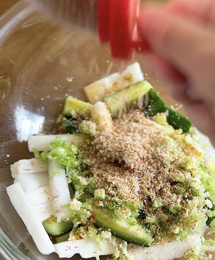 大根ときゅうりの和え物の仕上げにごまをふりかける