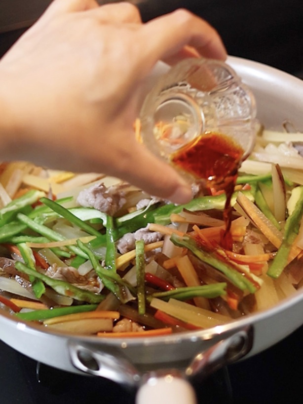 醤油やみりんできんぴらの味付けをします。