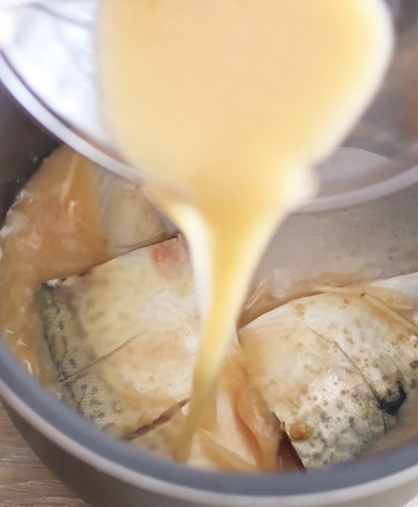 内釜に、鯖の上から調味料をかける工程