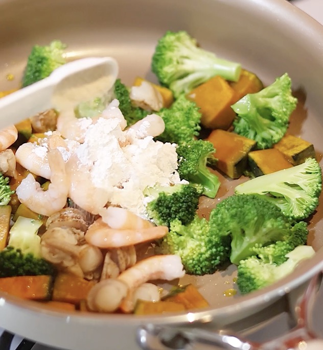 かぼちゃやブロッコリーの次に、シーフードミックスや米粉を加えて炒める