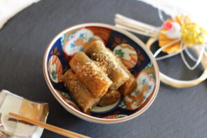 おせち料理 たたきごぼう（ピリ辛味噌味）の盛り付けと白ごまのトッピング