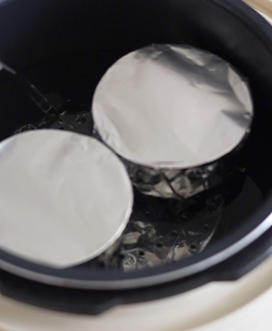 電気圧力鍋の内釜に容器の高さ半分程度まで水を入れ、容器を並べる。