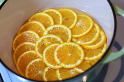 オランジェットの工程（ネーブルオレンジは皮をよく洗い、厚さ8mm程度の輪切りにする。鍋に砂糖と水1カップ（分量外）、ラム酒を入れて火にかける。）