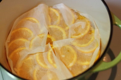 オランジェットの工程（砂糖が溶けたらオレンジを並べ入れ、落とし蓋（クッキングシート可）をして弱火で20〜30分煮る。シロップが冷めるまで待つ。）