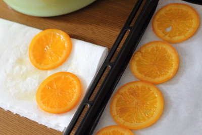 キッチンペーパーで、オレンジの余分なシロップをきる。

オランジェットの乾燥方法は、オーブンシートを敷いた天板に並べ、100〜110℃の低温のオーブンで60〜90分ほど、ベタつきがなくなるまで乾燥焼きする。