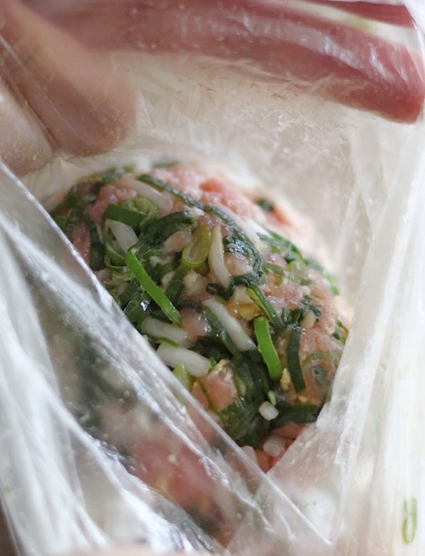 丸餃子の作り方（袋の上から粘りが出るまでよく揉み混ぜる。）