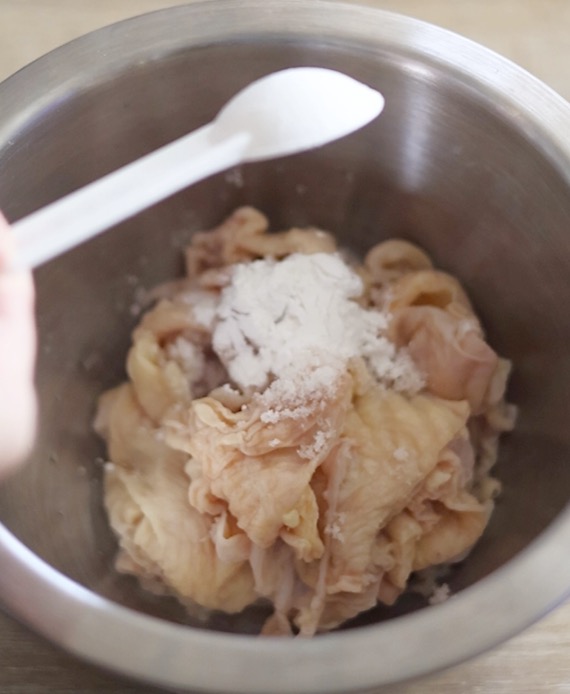 鶏皮に、塩、酒、米粉を加えてしっかり混ぜる