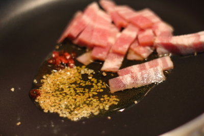 フライパンに、オリーブ油・ベーコン・粗びきガーリック・鷹の爪を入れて弱火にかけます。
