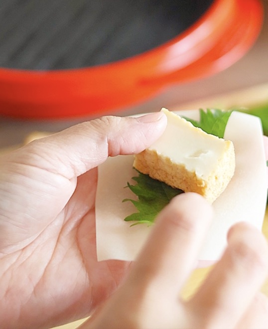 ワンタンの皮にねぎ梅みそを乗せて、大葉と厚揚げを巻いている工程