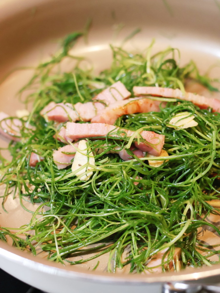 ベーコンに美味しそうな焼き色がついたら、にんにくスライスとおかひじきを加えて強火でさっと炒め合わせ、塩こしょうで味を調えます。
