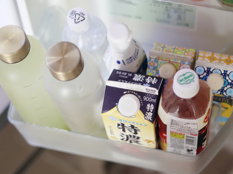 冷蔵庫のドアポケット下段に牛乳や飲み物を収納している様子