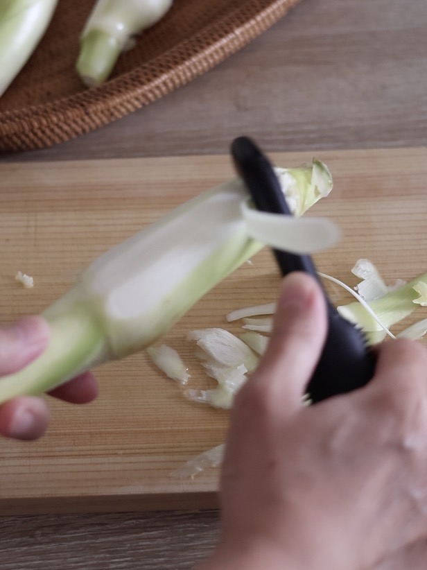 まこもだけは、白い部分だけを食べるので、かたい部分や薄緑の部分はピーラーや包丁でそぎます。