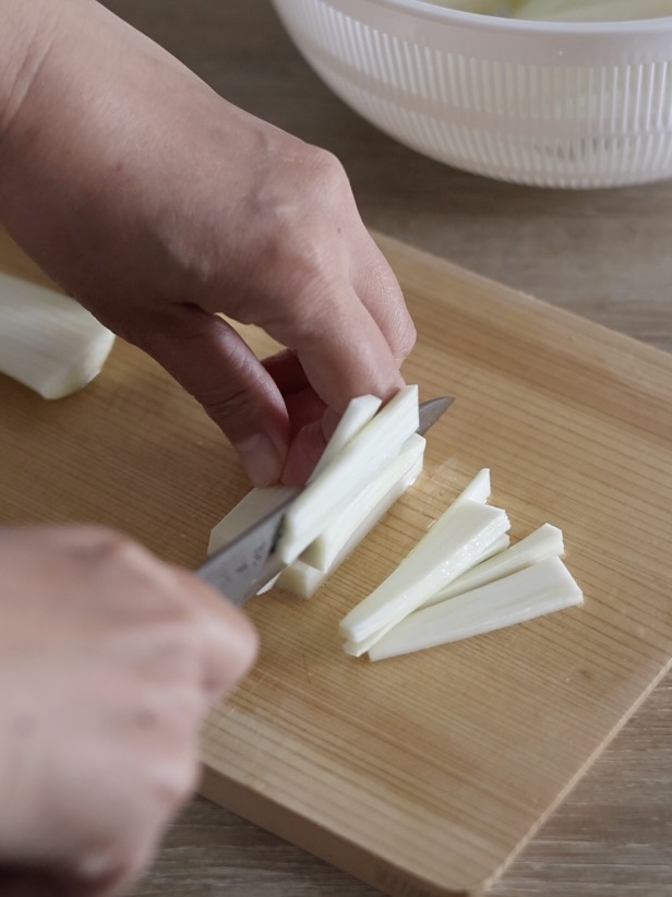 まこもだけの食感を残しつつ、繊維に沿って短冊切りにする様子
